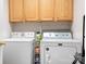This well-lit laundry room features front-loading washer/dryer, and cabinet for storing detergents and laundry needs at 136 Barringer Dr, Statesville, NC 28625