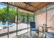 Enclosed patio with outdoor seating overlooking a deck and above-ground pool surrounded by lush greenery at 136 Barringer Dr, Statesville, NC 28625