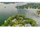 Aerial view of lakeside homes with manicured lawns on a verdant peninsula surrounded by calm waters at 145 Hunters Pointe Ln, Mooresville, NC 28117