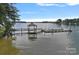 Dock featuring a gazebo and boat slips on a calm lake at 145 Hunters Pointe Ln, Mooresville, NC 28117
