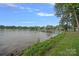 Lake view featuring a lush shoreline, a dock, and calm waters under a partly cloudy sky at 145 Hunters Pointe Ln, Mooresville, NC 28117