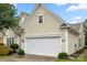 A view of the home's two car garage, siding, and a section of the landscaped front yard at 15152 Legend Oaks Ct, Indian Land, SC 29707