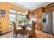 Sunlit kitchen nook with a glass table, wicker chairs, and wooden cabinetry offers a cozy dining space at 15152 Legend Oaks Ct, Indian Land, SC 29707