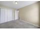 A bright bedroom has neutral walls, carpeted floor, closet and open door at 1744 Marsley Ln, Rock Hill, SC 29730