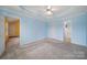 A bedroom with light blue walls, carpeted floors, ceiling fan and access to a bathroom at 1744 Marsley Ln, Rock Hill, SC 29730
