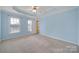 A bedroom with light blue walls, carpeted floors, ceiling fan and two windows at 1744 Marsley Ln, Rock Hill, SC 29730