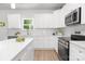 Bright kitchen features white cabinets, stainless steel appliances and an island with a white countertop at 1815 Wildwood Dr, Charlotte, NC 28214