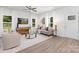 Open-concept living room with contemporary furnishings, hardwood floors, and large windows providing ample light at 1815 Wildwood Dr, Charlotte, NC 28214
