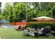 Private backyard with a hot tub, turf, patio furniture and mature trees provides a tranquil outdoor escape at 1833 The Plz, Charlotte, NC 28205