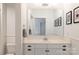 Bright bathroom vanity area with modern fixtures, framed art, and ample storage space at 1833 The Plz, Charlotte, NC 28205