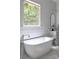 Luxurious bathroom featuring a freestanding tub, shiplap walls, and marble flooring at 1833 The Plz, Charlotte, NC 28205