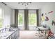 Bright bedroom with carpet, a desk, wall art, and lots of light from the windows at 1833 The Plz, Charlotte, NC 28205