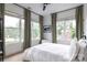 Well-lit bedroom with large windows, neutral colors, and a comfortable ambiance, creating a relaxing retreat at 1833 The Plz, Charlotte, NC 28205