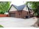 Exterior view of the two-story brick home featuring a garage, driveway, and landscaped surroundings at 1833 The Plz, Charlotte, NC 28205