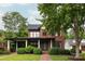 Beautiful brick home featuring a landscaped front yard with mature trees and covered entryway at 1833 The Plz, Charlotte, NC 28205