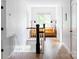 Bright hallway with hardwood floors and a glimpse of a sunlit seating area. Interior home design at 1833 The Plz, Charlotte, NC 28205