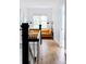 Inviting hallway with hardwood floors, black accents and view of the bright yellow couch through the large windows at 1833 The Plz, Charlotte, NC 28205