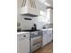 Close-up of a kitchen with stainless steel range, custom hood, quartz countertops, and white cabinets at 1833 The Plz, Charlotte, NC 28205
