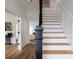 Elegant staircase with hardwood steps and white painted risers and banisters at 1833 The Plz, Charlotte, NC 28205