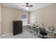 Well-lit bedroom with a sewing machine, gray dresser, and a neutral-colored ceiling fan at 1907 Sandal Brook Rd, Fort Mill, SC 29707