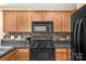 Well-equipped kitchen offers black appliances, functional cabinetry, and tiled backsplash at 1907 Sandal Brook Rd, Fort Mill, SC 29707