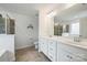 Bathroom with double sinks, white cabinets, tile floors, and a tiled shower at 198 Wrangell Dr, Mooresville, NC 28117