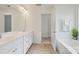 Bright bathroom featuring a double vanity, white cabinetry, and a separate tub at 198 Wrangell Dr, Mooresville, NC 28117