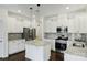 Modern kitchen boasts white cabinets, stainless steel appliances, and a center island with a light countertop at 198 Wrangell Dr, Mooresville, NC 28117