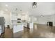 Open-concept kitchen features a center island, stainless steel appliances, and seamless flow into the living area at 198 Wrangell Dr, Mooresville, NC 28117