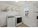 Well-lit laundry room equipped with a washer, dryer, shelving and a window, making chores a breeze at 198 Wrangell Dr, Mooresville, NC 28117