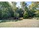 Private backyard with mature trees, lush landscaping, and well-manicured lawn at 2035 Beacon Ave, Monroe, NC 28110