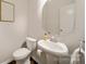 Bathroom featuring a pedestal sink, toilet, decorative mirror and dark wood-look flooring at 2035 Beacon Ave, Monroe, NC 28110