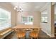 Bright dining room with bench seating, wood table, modern lighting, and sliding door leads to outdoor living area at 2035 Beacon Ave, Monroe, NC 28110