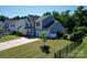 Inviting two-story home featuring a lush lawn, mature trees, and a two-car garage at 2035 Beacon Ave, Monroe, NC 28110