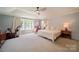 Light-filled main bedroom features a vaulted ceiling, ceiling fan, large windows and neutral walls at 2035 Beacon Ave, Monroe, NC 28110