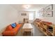 Spacious playroom with an orange futon, white table, and dark hardwood floors at 2035 Beacon Ave, Monroe, NC 28110