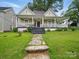 Charming house featuring a welcoming front porch, complemented by a well-maintained lawn and inviting walkway at 211 S Rowan Ave, Spencer, NC 28159