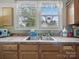 Well-lit kitchen sink area with a view and practical storage solutions at 211 S Rowan Ave, Spencer, NC 28159