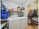 Cluttered laundry room with side-by-side washer and dryer and shelving unit at 211 S Rowan Ave, Spencer, NC 28159