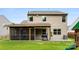 Exterior backyard featuring a screened in patio, grill, well manicured lawn and partial view of a two-story home at 225 Tasman Dr, Mount Holly, NC 28120