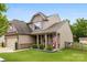 Inviting two-story home with a covered front porch, American flag, and a fenced yard at 225 Tasman Dr, Mount Holly, NC 28120