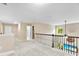 Bright and airy loft featuring neutral walls, plush carpeting, and a decorative wrought iron railing overlooking the living area at 225 Tasman Dr, Mount Holly, NC 28120