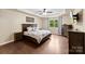 Bedroom with tray ceilings, hardwood floors, a ceiling fan and generous natural light from a large window at 225 Tasman Dr, Mount Holly, NC 28120