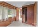A cozy bedroom with carpet, wood paneled walls, closet and windows that look out onto the front yard at 3345 Long Ferry Rd, Salisbury, NC 28146