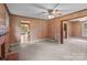 A cozy living room featuring carpeted floors, wood-paneled walls, a brick fireplace, and a ceiling fan at 3345 Long Ferry Rd, Salisbury, NC 28146