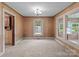 Living room with carpeted floors and wood paneled walls with multiple windows providing lots of natural light at 3345 Long Ferry Rd, Salisbury, NC 28146
