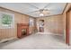 Cozy living room featuring a brick fireplace, carpet floors, wood panel walls, and a ceiling fan at 3345 Long Ferry Rd, Salisbury, NC 28146