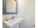 Close-up of pedestal sink with modern faucet and decorative mirror in a well-lit bathroom at 3722 Ellington St, Charlotte, NC 28211