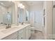 Elegant bathroom featuring double sinks, white cabinetry, and a glass-enclosed shower at 3722 Ellington St, Charlotte, NC 28211