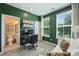 Inviting home office with green walls, a modern desk setup, and ample natural light from the windows at 3722 Ellington St, Charlotte, NC 28211